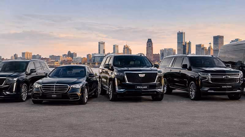Boston Limo Time fleet of sedan, SUV, and Sprinter van with downtown Boston in the background